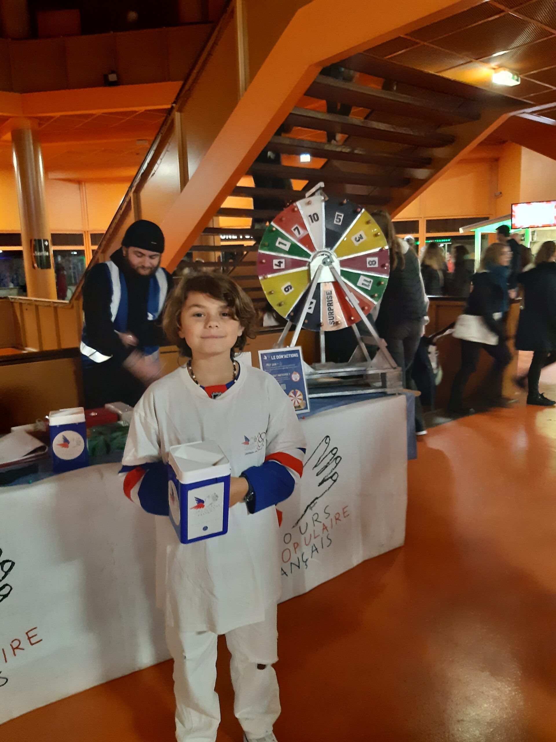 Un garçon tient un tronc de collecte pendant une animation