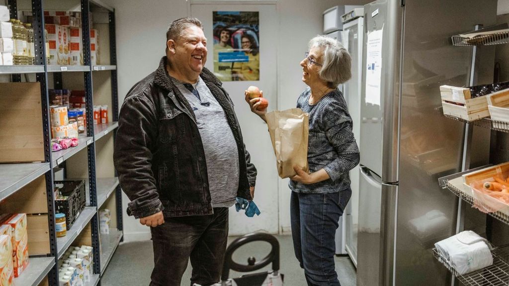 Moment de détente entre une personne aidée et une bénévole, au libre-service alimentaire à Lyon