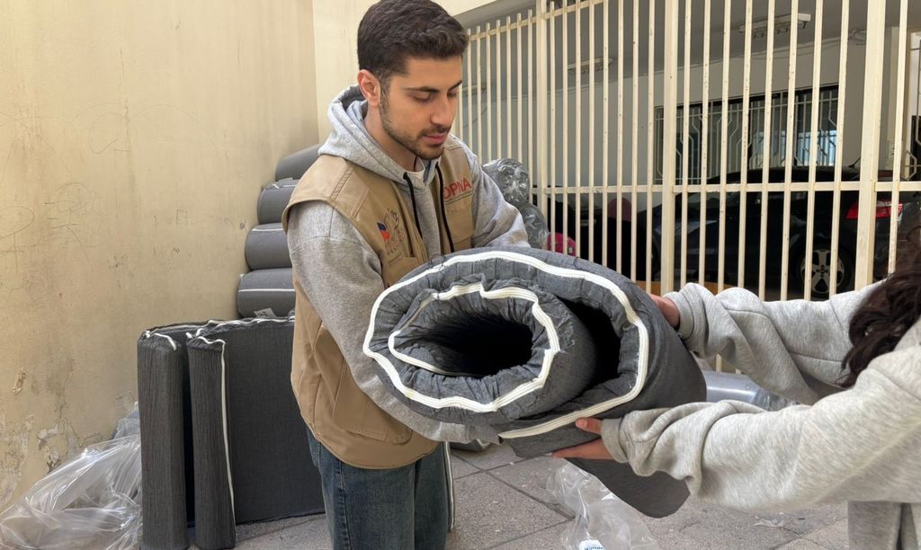 Un bénévole du DPNA distribue des matelas - 5 mars 2026, Saïda, Liban