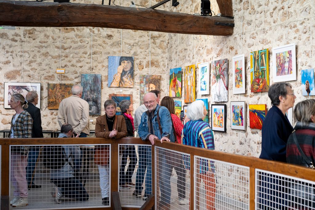 Un ensemble d'individus sur la mezzanine observant les œuvres d'art. © Béatrice Usseglio