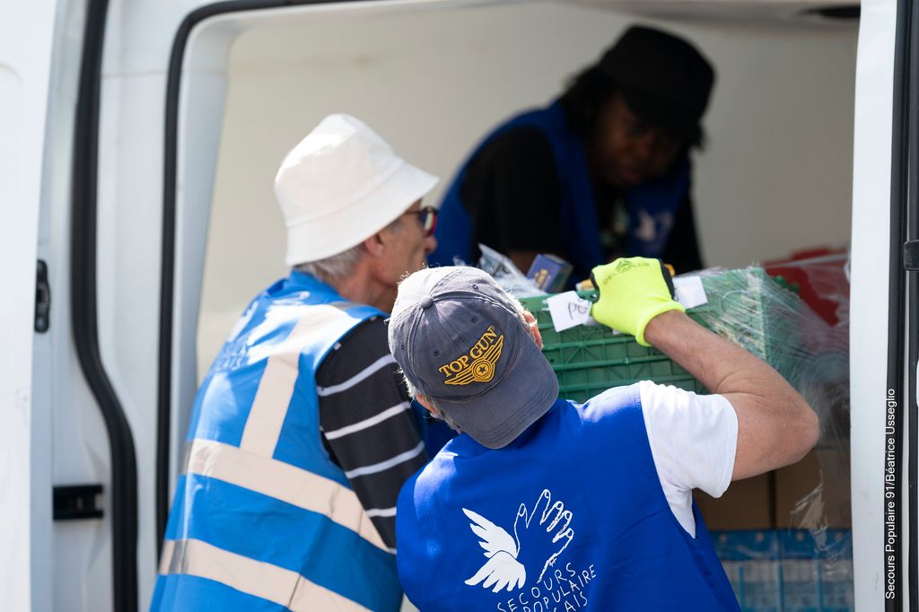 Des bénévoles du Secours populaire qui déchargent le camion 
