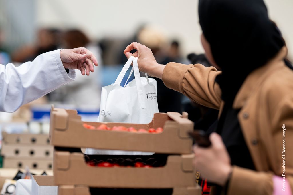Une personne aidée qui reçoit un sac pendant la distribution du Solidaribus.