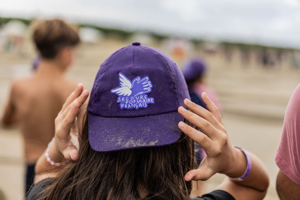 Une enfant, de dos et en gros plan, arbore une casquette violette.
