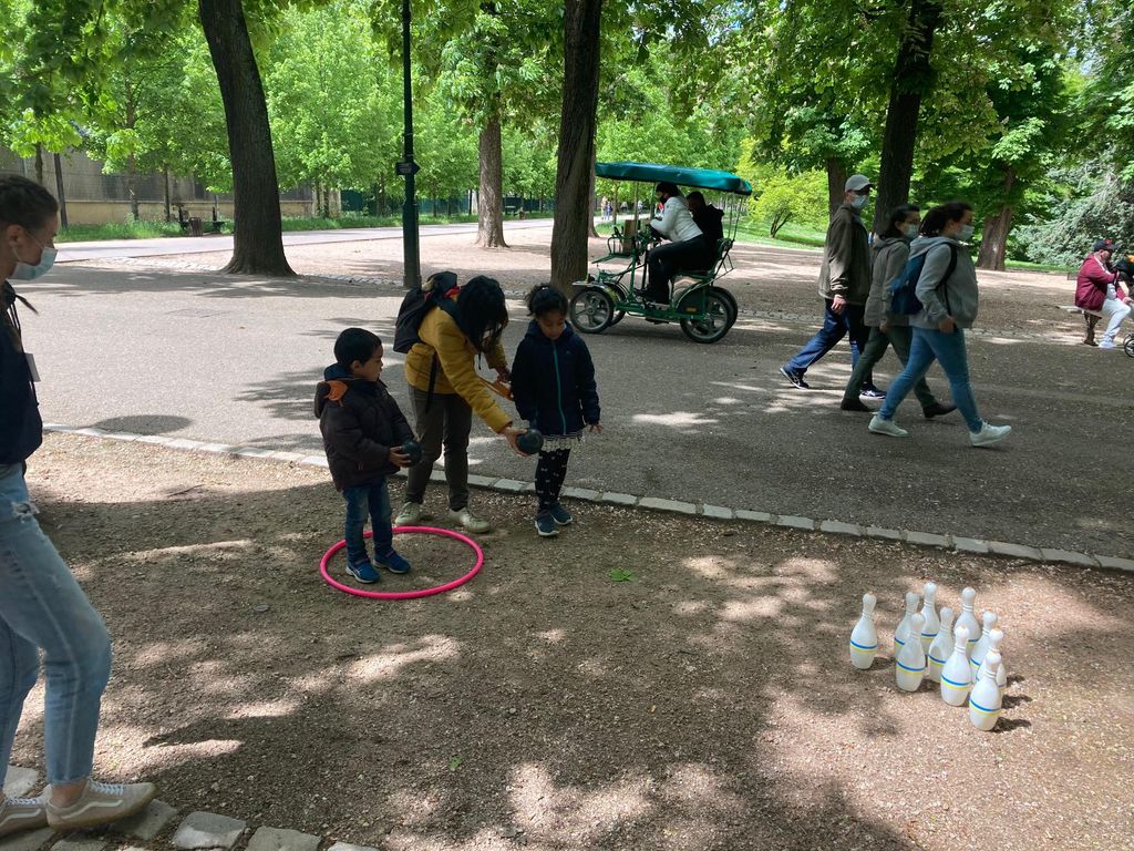 Des enfants dont un jeu de piste avec un bénévole du Secours populaire