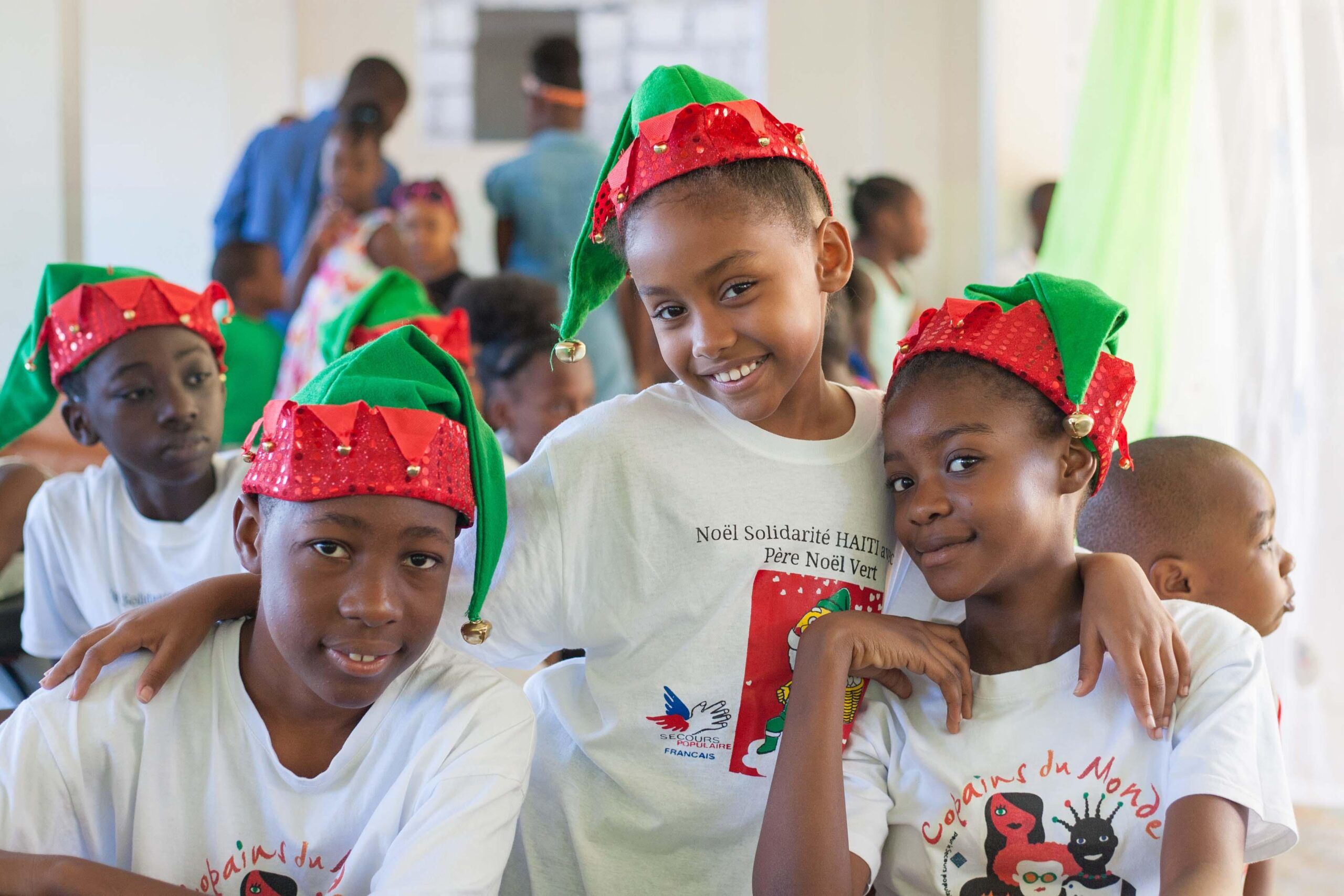 En Haïti, le 24 décembre 2018, les enfants ont revêtu les bonnets verts du Secours populaire pour faire la fête avec le SPF et l'AHCD. A Noël, le SPF repeint le monde en vert