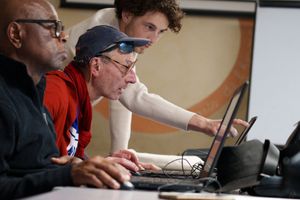 Des personnes aidées participent à un atelier numérique qu'animent des bénévoles.