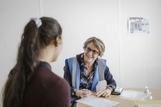Une bénévole du Secours populaire accueil une jeune femme