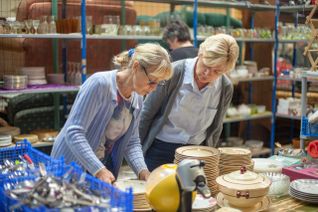 2 femmes bénévoles au Secours populaire français, trient de la vaisselle avant la braderie.