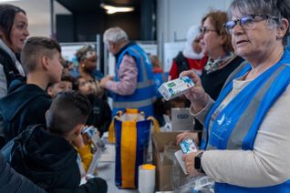 Deux bénévoles distribuent des dentifrices.