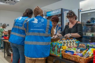 Bénévoles et personnes accompagnées par le Secours populaire français qui discutent.