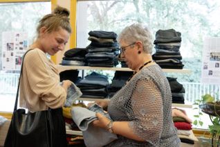 Interactions entre une bénévole du Secours populaire français et une jeune femme, venue voir des vêtements lors d'une braderie.