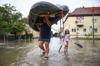 Un homme et une petite fille portent un bateau gonflable alors que la rivière Nysa Klodzka a inondé la ville de Lewin Brzeski dans le sud-ouest de la Pologne, le 19 septembre 2024.