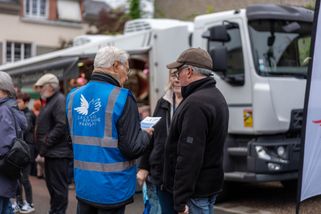 Les bénévoles discutent sur le marché avec des clients