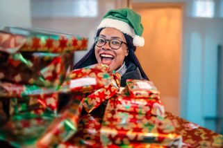 Une bénévole tient une montagne de cadeaux entre ses bras