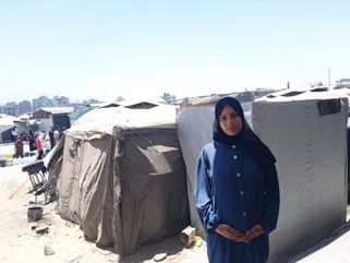 Dina Al-Nahhal, devant la tente qu'elle occupe dans le camp de déplacés de Sheikh-Radwan, dans la ville de Gaza. Juillet 2025