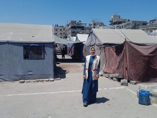Weam Kilani, devant le camp de Sheick Radwan, dans la ville de Gaza où elle travaille en tant que sage-femme pour PMRS.