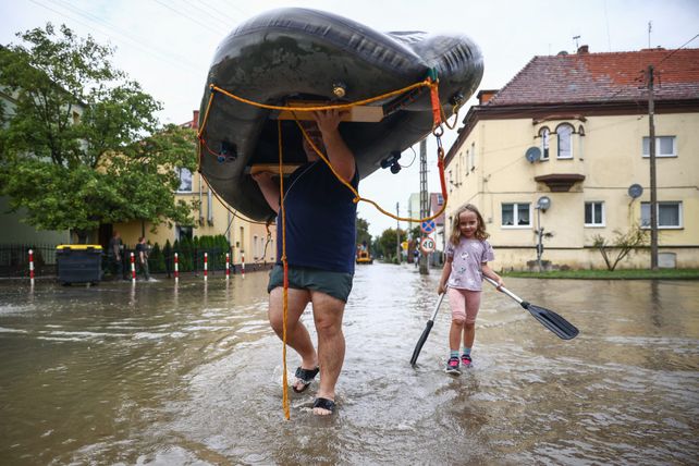 Un homme et une petite fille portent un bateau gonflable alors que la rivière Nysa Klodzka a inondé la ville de Lewin Brzeski dans le sud-ouest de la Pologne, le 19 septembre 2024.