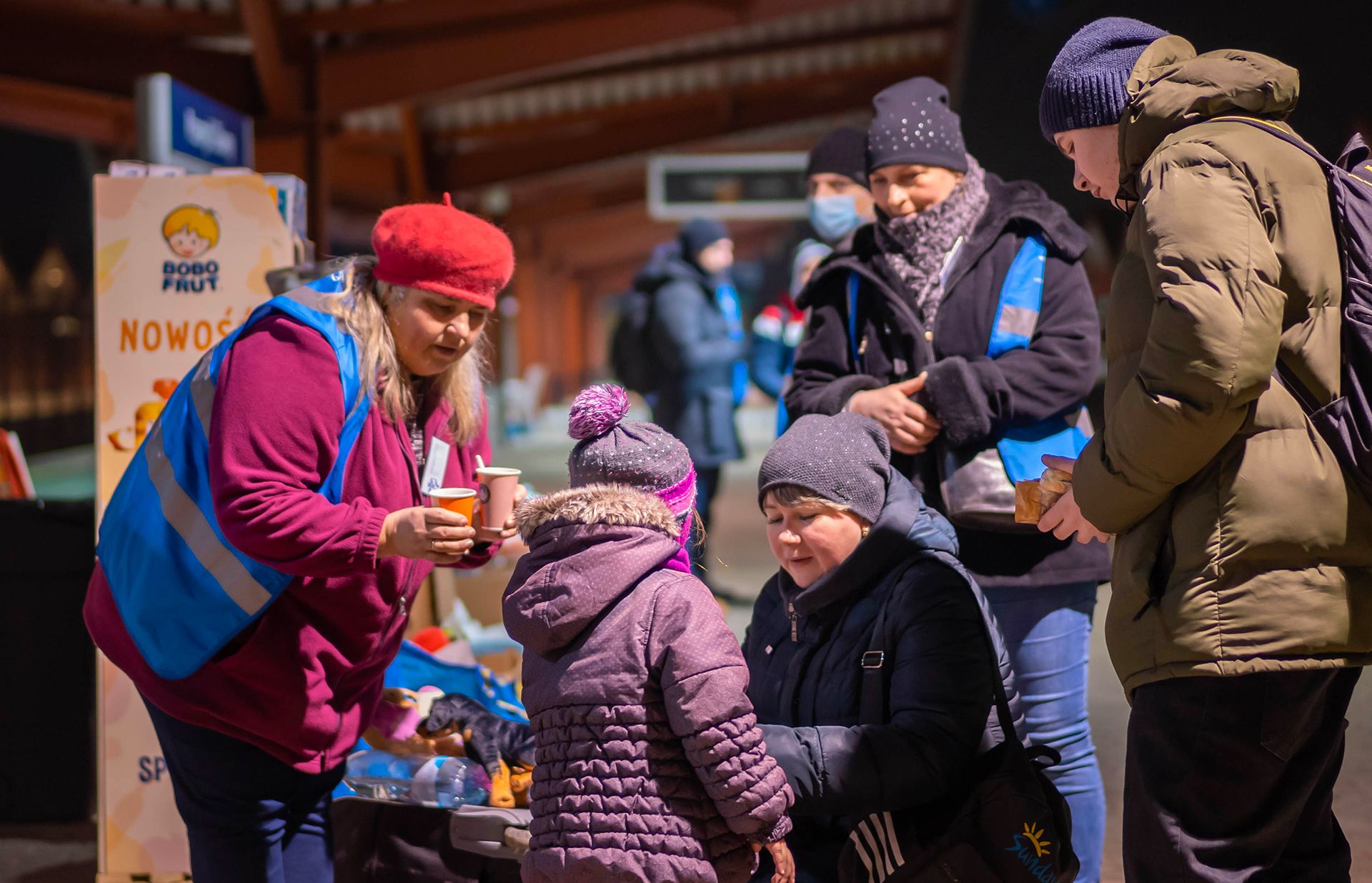 Des bénévoles offrent des boissons chaudes aux réfugiés qui arrivent.