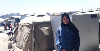 Dina Al-Nahhal, devant la tente qu'elle occupe dans le camp de déplacés de Sheikh-Radwan, dans la ville de Gaza. Juillet 2025