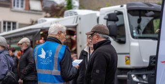 Les bénévoles discutent sur le marché avec des clients