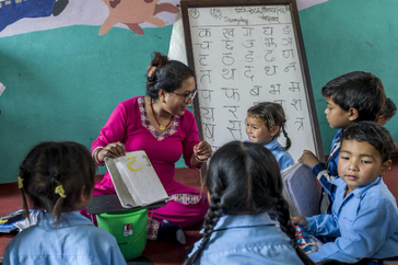 Une enseignante faisant la classe dans une école réhabilitée par UEMS et le Secours populaire.