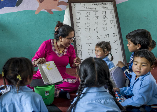Une enseignante faisant la classe dans une école réhabilitée par UEMS et le Secours populaire.