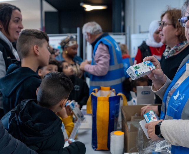 Deux bénévoles distribuent des dentifrices.